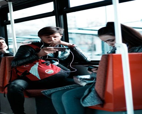 Person checking phone while commuting on a bus