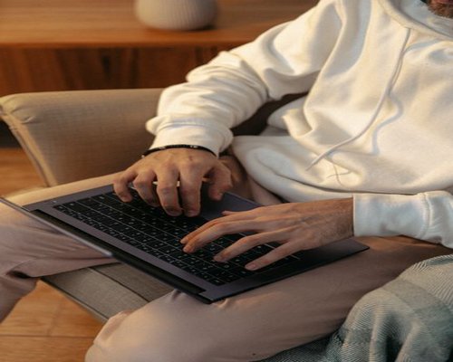 Person typing on a laptop at a comfortable desk
